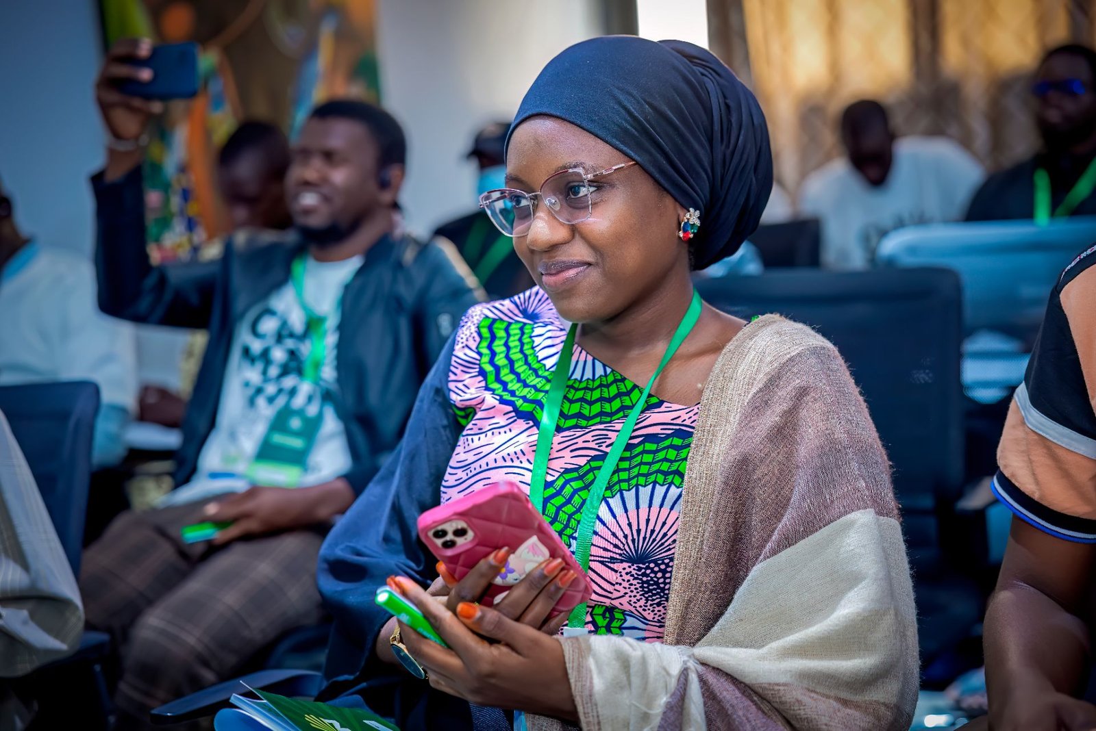 A participant smiling at her phone during a programme session